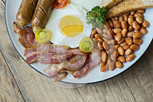 Fried bacon with beans and sausage on the plate