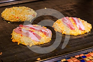 Fried Bacon on cheese and doughs, making Okonomiyaki ,Japanese fried pizza, selected focus.