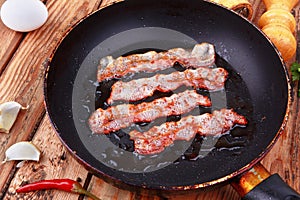 Fried bacon in a frying pan