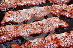 Fried bacon in a frying pan