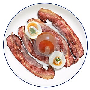 Fried Bacon Rashers With Hard Boiled Garnished Egg Slices And Tomato Set On White Porcelain Plate Isolated On White Background