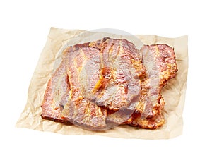 fried bacon strips on a parchment isolated on white background