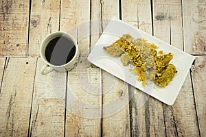 Fried Banana (Pisang Goreng), traditional snack in Malaysia with black coffee cup.