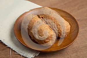 Fried bananas in wooden plate on white linen, Kluay Tod - Thai dessert