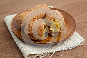 Fried bananas in wooden plate on white linen, Kluay Tod - Thai dessert