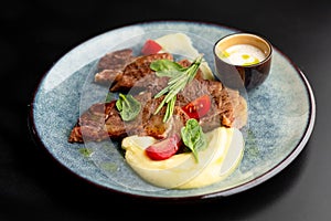 Fried beef mumm with mashed potatoes, served on a gray plate on a black background. photo