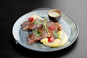 Fried beef mumm with mashed potatoes, served on a gray plate on a black background. photo