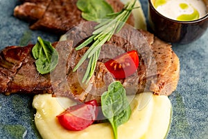 Fried beef mumm with mashed potatoes, served on a gray plate on a black background. photo