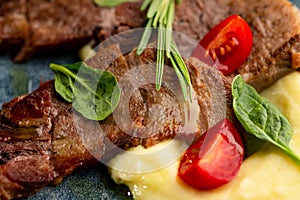 Fried beef mumm with mashed potatoes, served on a gray plate on a black background. photo