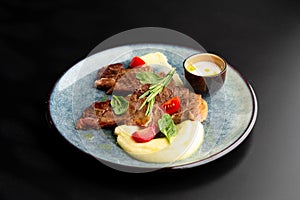 Fried beef mumm with mashed potatoes, served on a gray plate on a black background. photo