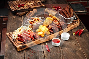 Fried beer snacks on the wooden board with sauces