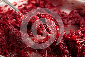 Fried beetroot in frying pan, spoon close-up, selective focus. Ingredient for borscht or vegetarian salad