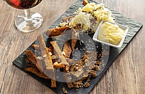 Fried black rye bread toasts with cheese salt and spices, on a plate