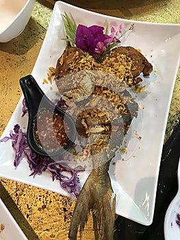 Fried Blacked-banded trevally with garlic in Thailand.