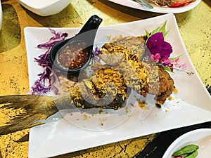 Fried Blacked-banded trevally with garlic in Thailand.