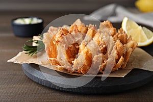 Fried blooming onion served on wooden table, closeup