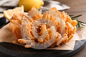 Fried blooming onion served on wooden table, closeup