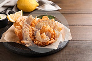 Fried blooming onion served on wooden table. Space for text