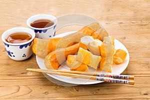 Fried bread stick or You Tiao served with Chinese tea on wooden table