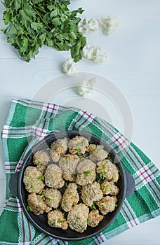 Fried breaded cauliflower. Dish in a small pan. White wood background. Space for text