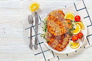 fried breaded chicken breast cutlets on plate photo