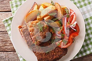 Fried Breaded rump steak with potato and vegetables close-up. ho