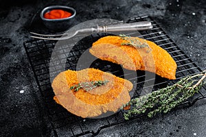 Fried Breaded weiner schnitzel, cooked meat steak. Black background. Top view