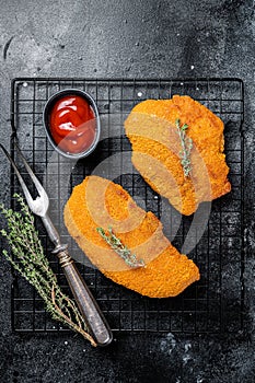 Fried Breaded weiner schnitzel, cooked meat steak. Black background. Top view