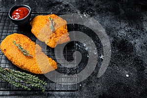 Fried Breaded weiner schnitzel, cooked meat steak. Black background. Top view. Copy space