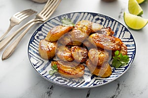 Fried caramelized plantains served with lime wedges