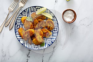 Fried caramelized plantains served with lime wedges