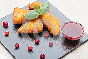 Fried cheese sticks served with cranberries, sauce on black stone