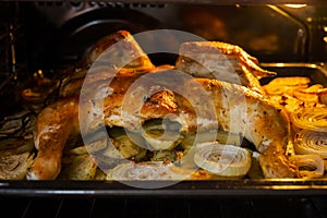 Fried chicken with baked potatoes and onions in the oven