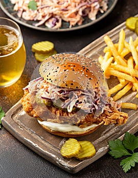 Fried chicken burger, sandwich with coleslaw, pickled gherkins, mayonnaise and beer. Fast food.