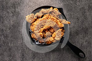 Fried chicken, crispy, in a black pan