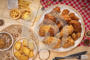 Fried chicken egg tart and french fries in wooden plate on wooden background, Deep fry Chicken and nuggets on wooden table.