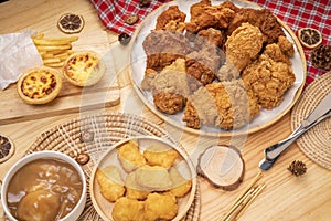 Fried chicken egg tart and french fries in wooden plate on wooden background, Deep fry Chicken and nuggets on wooden table.