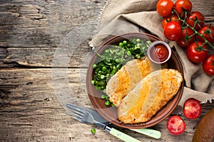 Fried chicken fillet with cheese crust and garnish of fresh vegetables, healthy food