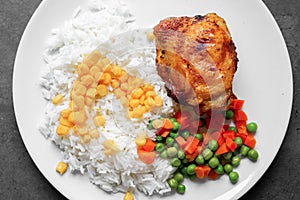 Fried chicken leg with rice, corn, carrots and peas