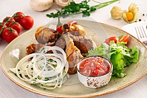 Fried chicken leg with tomato sauce and mixed salad in a serving dish. Copyspace