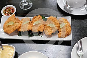 Fried chicken with lemon slice and fried basil.