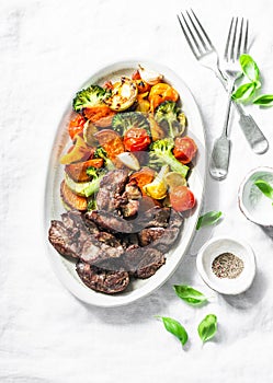 Fried chicken liver and baked seasonal vegetables - delicious healthy lunch on light background