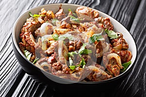 Fried chicken liver, heart and stomachs with onions, tomatoes and spices close-up in a bowl. horizontal