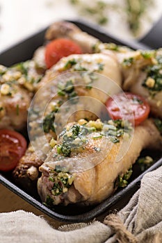 Fried chicken in pesto sauce with fresh herbs and cherry tomatoes