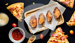 Fried Chicken and Pizza black background.Top view