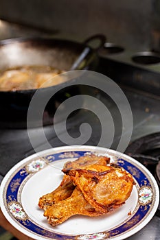 Fried chicken in a plate with a gas stove background