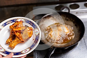 Fried chicken in a plate with a gas stove background