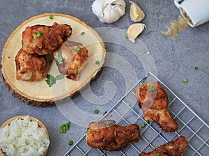 Fried chicken`s wings in wooden plate on cement background