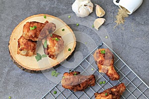 Fried chicken`s wings in wooden plate on cement background