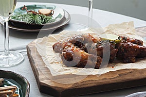 Fried chicken served on a cutting board. served christmas table. glasses with champagne.